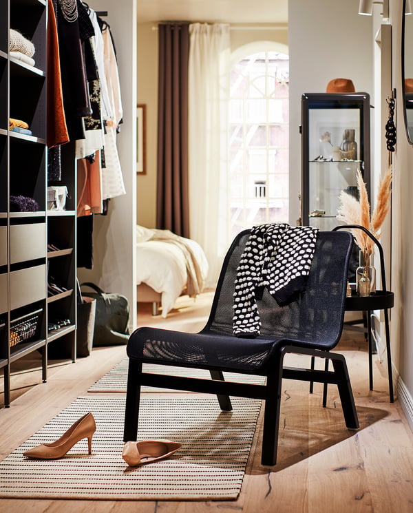 Modern black NOLMYRA mesh easy chair, stylish bedroom with closet.