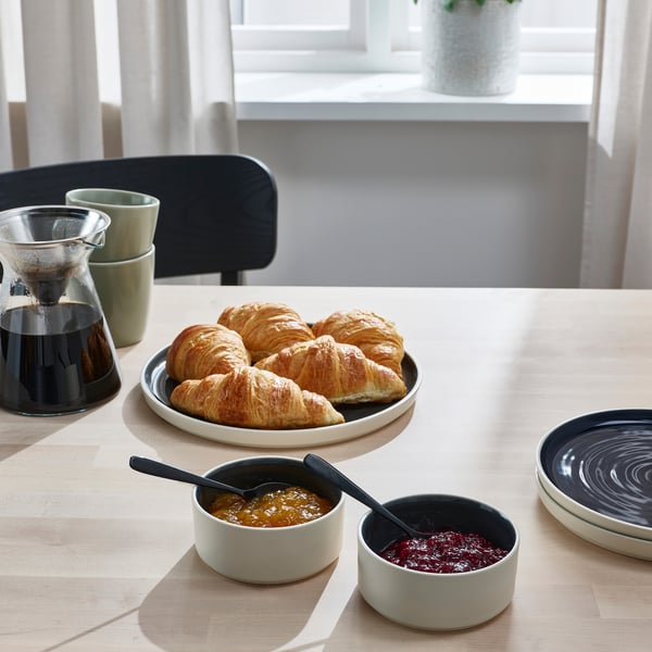 Breakfast table set with croissants, jams, and coffee.