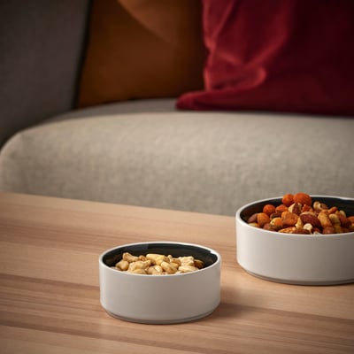 Two bowls on a wooden table: one with nuts, the other with dried fruit. Part of OMBONAD series for snacks and breakfast.