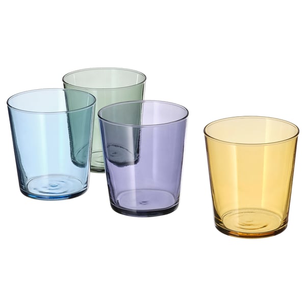 Four PAPPERSBJÖRK glasses in blue, green, purple, and yellow, made of glass and coloured paint, arranged in a group.