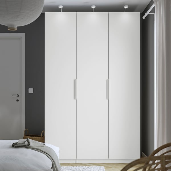 Modern bedroom with large white PAX wardrobe, tall and sleek, contrasting dark wall. ,