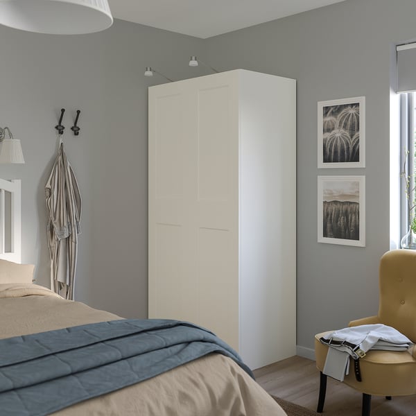 Alt: white PAX wardrobe with bedding and chair.