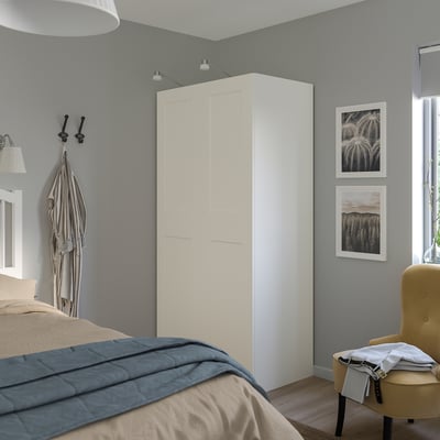 Alt: white PAX wardrobe with bedding and chair.