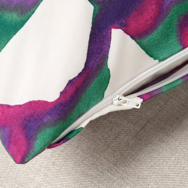 A zip on a colourful leaf-patterned cushion cover.