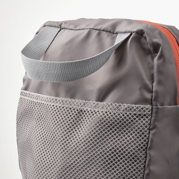 Grey backpack with drawstring top and mesh front pocket. Shoulder straps adjusted for comfort.