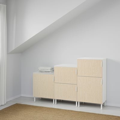 Minimalist room with PLATSA storage, tan rug, white walls, tall curtain.