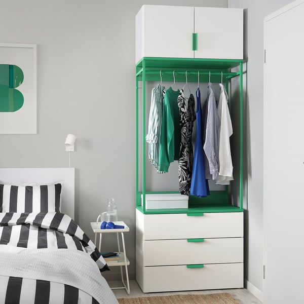 Modern bedroom with white-green PLATSA wardrobe, striped bedding, ample storage.