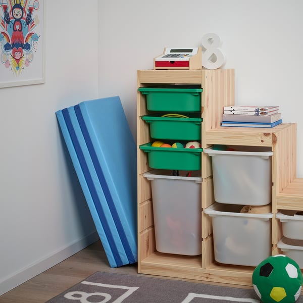 Kids play area with blue PLUFSIG mat for practising gymnastic moves, wooden storage bins with toys, and colourful decor.