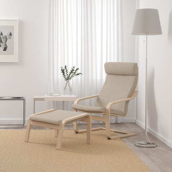 POÄNG armchair & footstool in beige/birch, modern minimalist design, large, with floor lamp, side table, and decor.