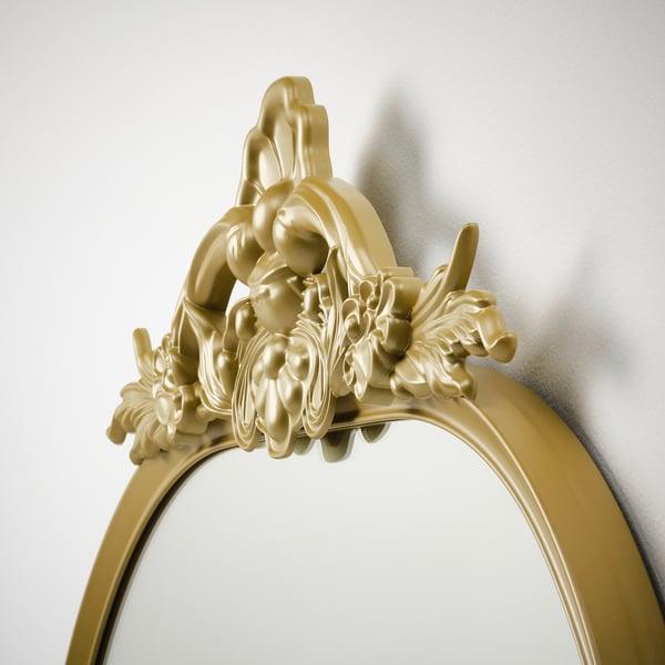 Golden ornate mirror with intricate designs, reflecting quality craftsmanship and vintage style.