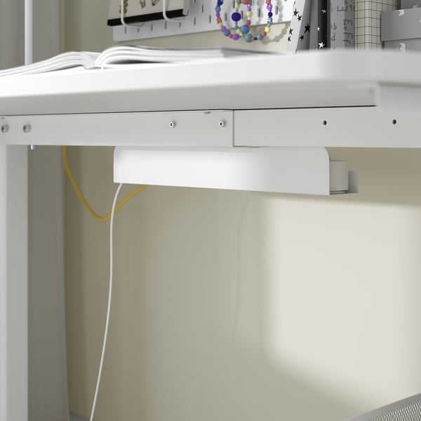 White adjustable desk, yellow cable, bead toy, books, metal shelf, wheels.