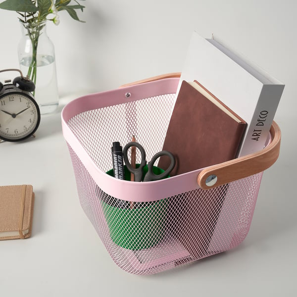 Mesh basket with notebooks, scissors, pens. Organises office and fruit supplies, has wooden handle for carrying.