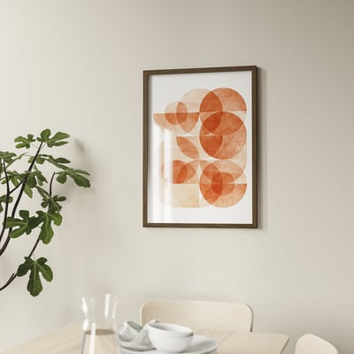 Geometric art above dining table set with white dishes and plant. Framed securely with plastic and hooks.