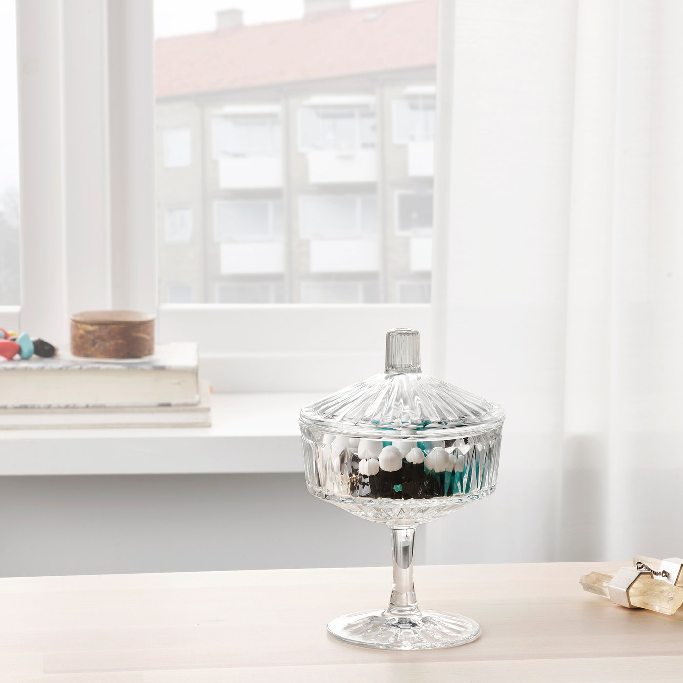 SÄLLSKAPLIG glass canister with candies on table by window.