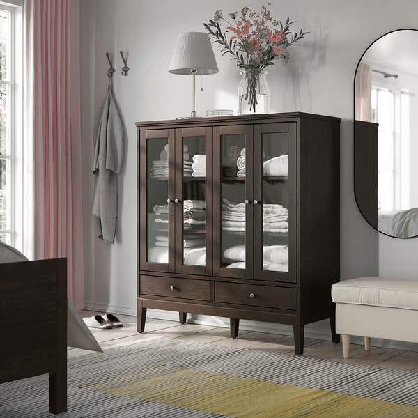 Modern bedroom with SJÖTÅTEL cabinet, towel, lamp, mirror, striped rug, coat, curtains, bench, bed.
