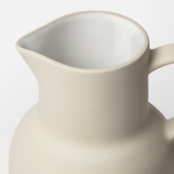 Myopic beige stoneware jug with matte finish, smooth texture, and wide handle. Crafted by skilled artisans in thailand.