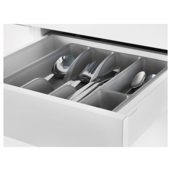 White drawer organiser holding cutlery: spoons, forks, knives, and a ladle.