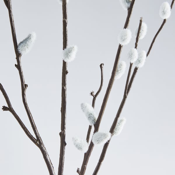 Artificial branches with fuzzy white buds, realistically arranged against a light sky.