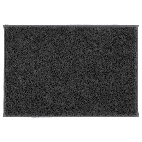 A dark grey SÖDERSJÖN bath mat. It has a rectangular shape with a plush cotton surface and latex backing for grip.