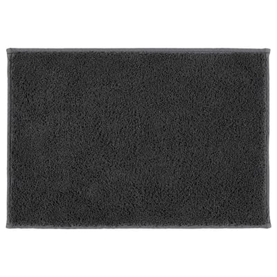 A dark grey SÖDERSJÖN bath mat. It has a rectangular shape with a plush cotton surface and latex backing for grip.