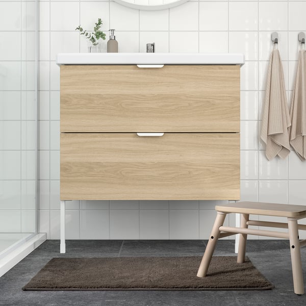 Modern bathroom with light vanity and brown bath mat.