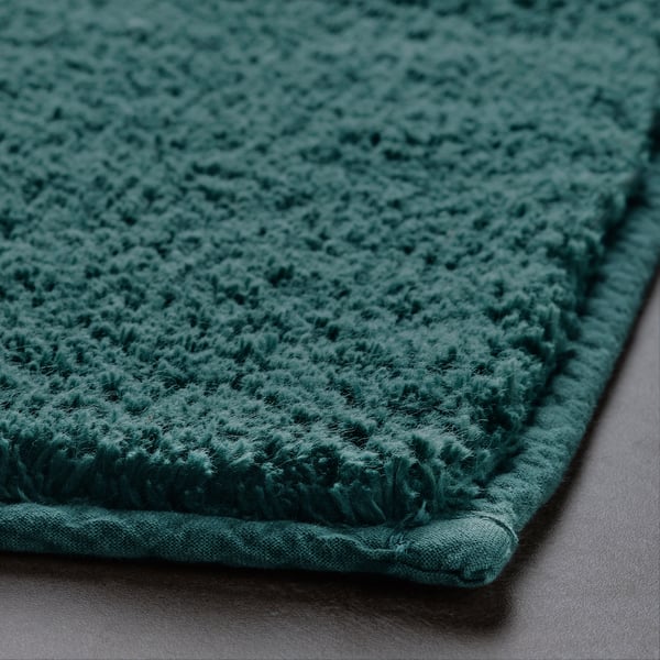 Thick, soft turquoise bath mat close-up, showcasing plush cotton pile texture and sturdy backing.