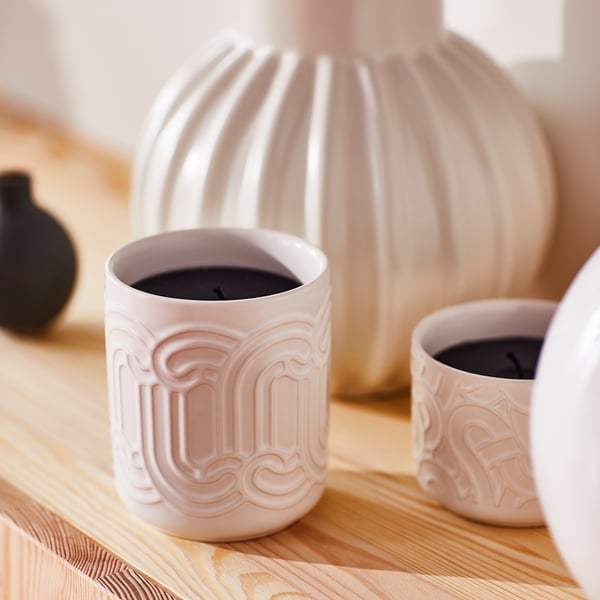 White SÖTRÖNN candles on wood, various sizes, textured vase.