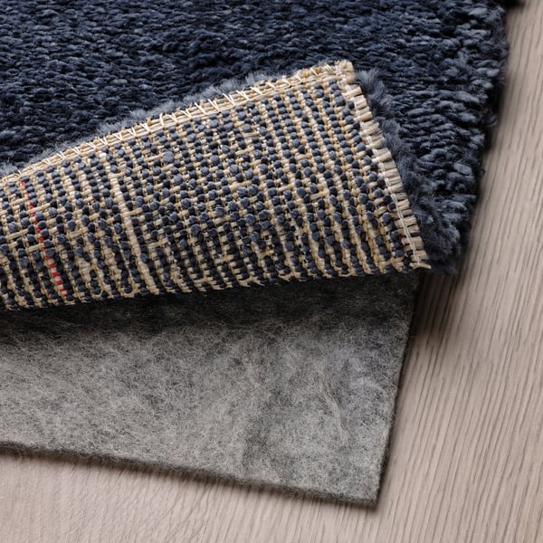 Cosy, thick rug layers on wooden floor; demonstrates sound dampening feature.