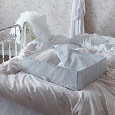 Bed with white STUK storage box, grey grid pattern, fabric sides, rectangular shape.