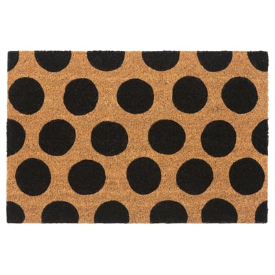 A TÅGFORDON doormat with black polka dots on a natural coir background. The mat is square-shaped and made from eco-friendly materials.