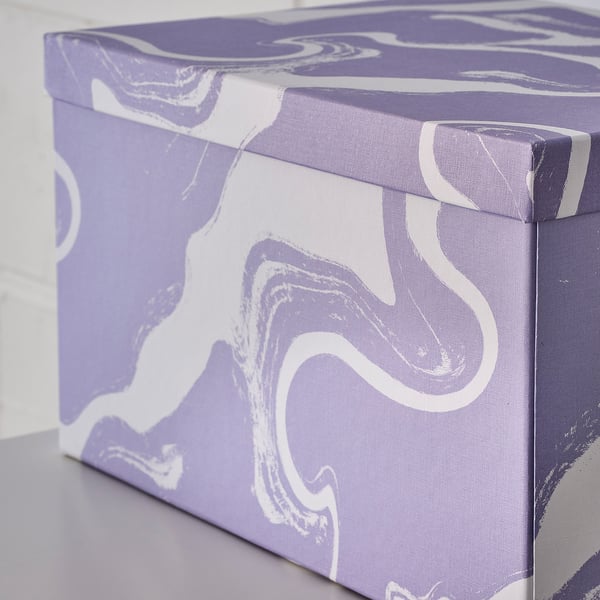 Decorative lavender TJENA storage box with white swirls, rectangle-shaped, made of recycled paperboard.