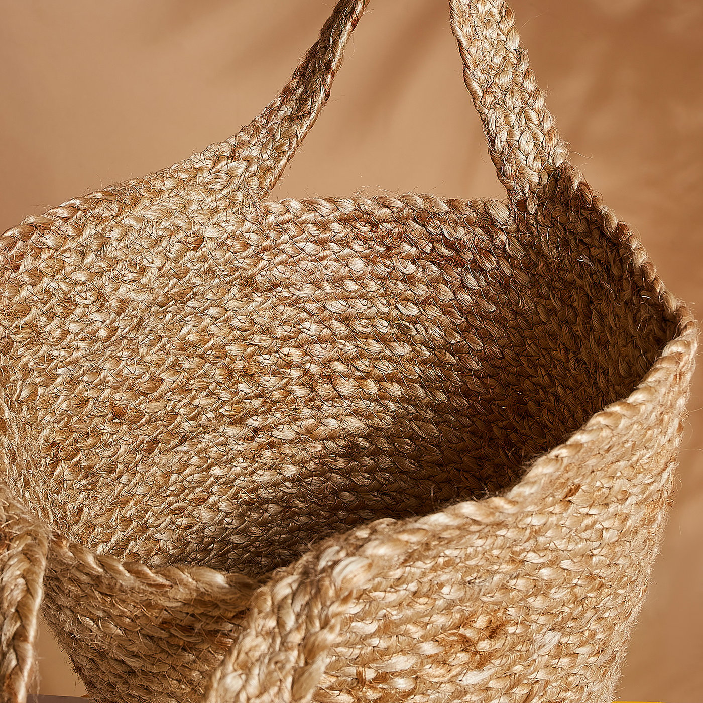 Handcrafted jute basket, braided with natural fibres, showcasing warm textures and sturdy handles.