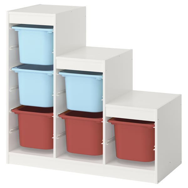 The TROFAST storage unit with blue and red plastic bins on white shelves. Its designed for children to organise their belongings.