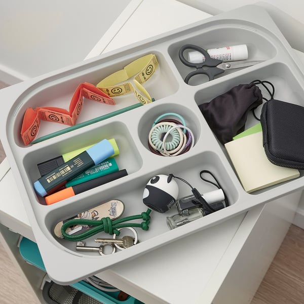 Organised storage tray with various kids items like pens, scissors, and accessories, perfect for keeping small things neat.