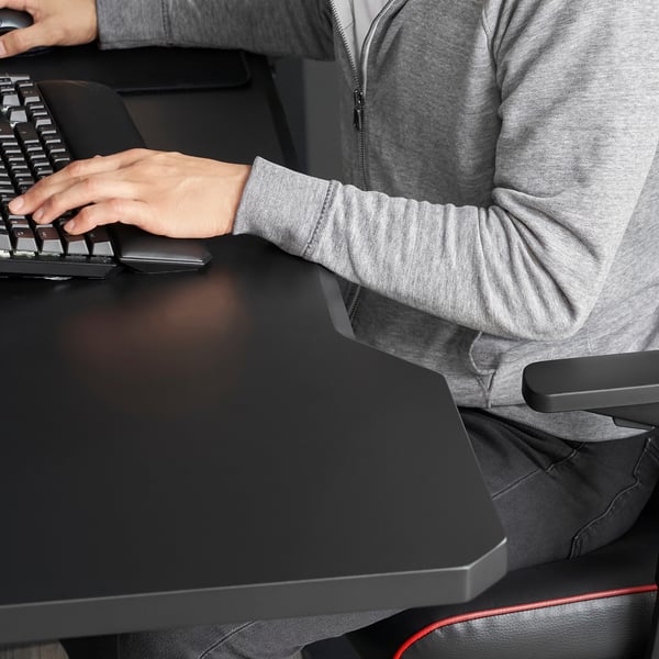 Person typing at computer desk; tabletop positions provide wrist relief and allows cable management.