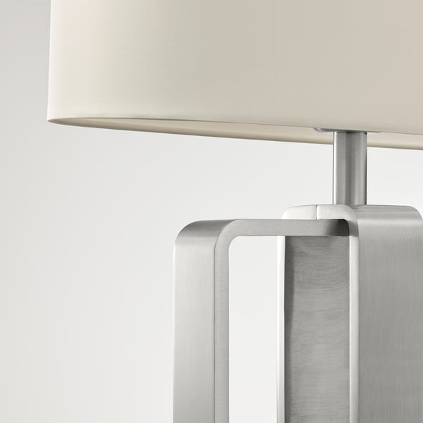 Modern table lamp with sleek metal base and off-white shade. Premium materials ensure durability and stylish lighting.