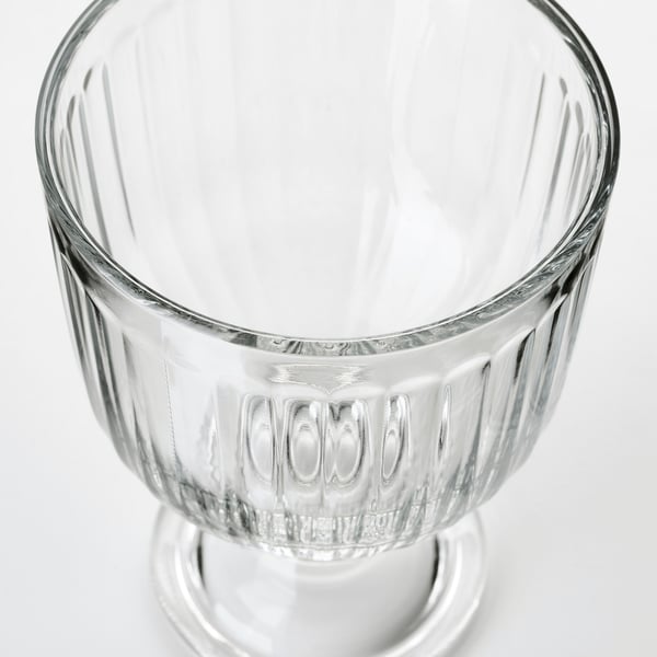 Elegant, clear glass cup with ribbed texture, wide rim, and stable base. Classic design for various beverages.