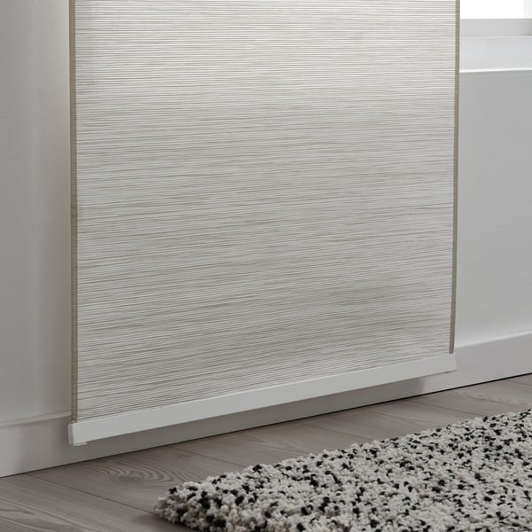Minimalist roller blind on modern wood floor with textured rug.
