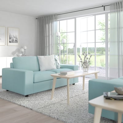 Modern blue VIMLE sofa in serene living room, centre coffee table, large windows.