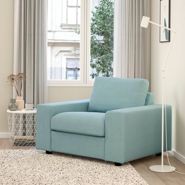 Blue VIMLE armchair in living room with rug and floor lamp.