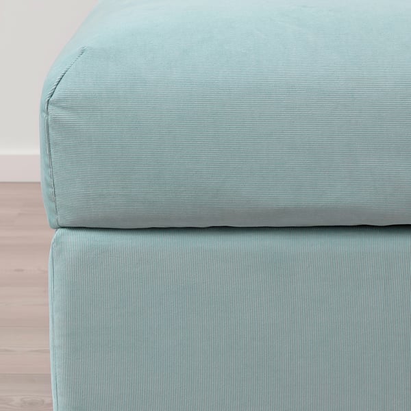 Teal fabric footstool, neatly stitched, soft yet structured, perfect for extra seating or resting feet.