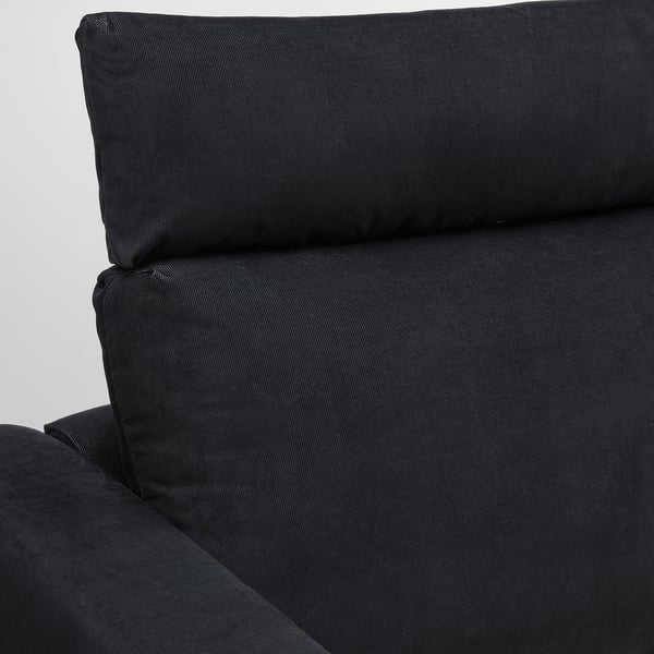 Modern black corduroy sofa, plush cushions, elegant design, invites comfort.