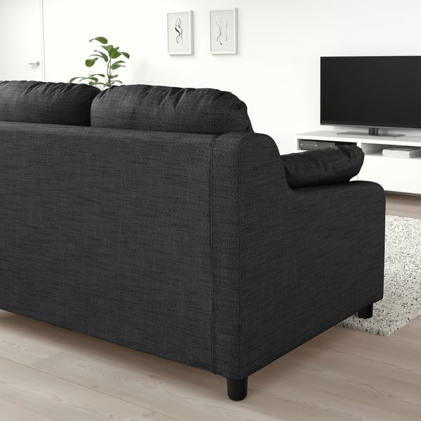 Modern living room with large black VINLIDEN sofa, tv, and decor.