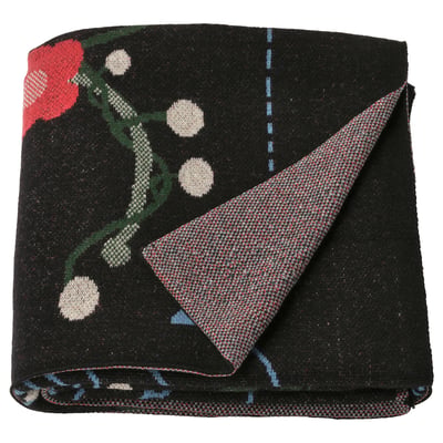 Black VINTERFINT fleece throw with red flowers, white circles, folded, wool/cotton blend.
