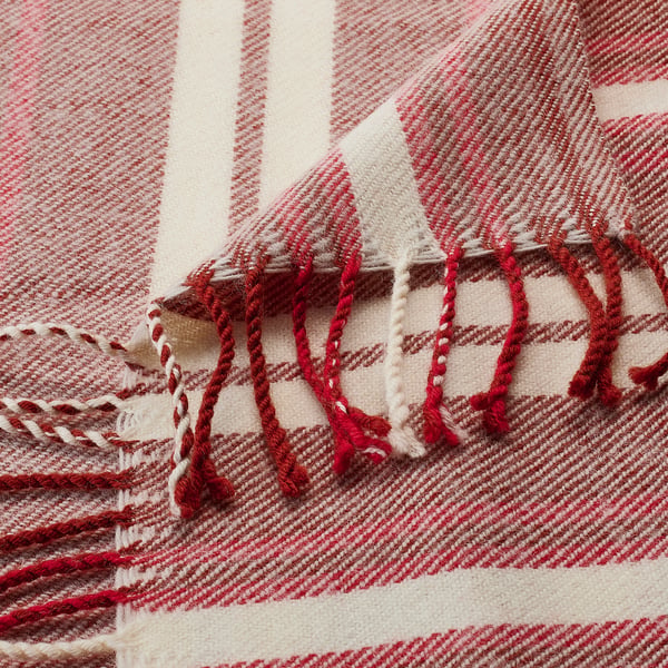 Red and white striped wool blanket with fringe. Soft, warm, high-quality texture.