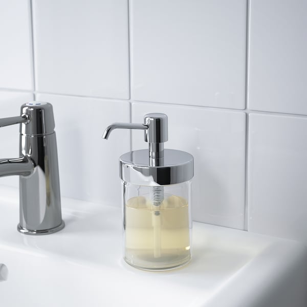 Clear soap dispenser with chrome pump on bathroom sink, part of VOXNAN series.
