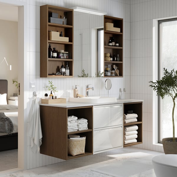 Modern white & wood bathroom setup, ÄNGSJÖN. Central sink, open & closed storage. Neat, organised, sleek design.