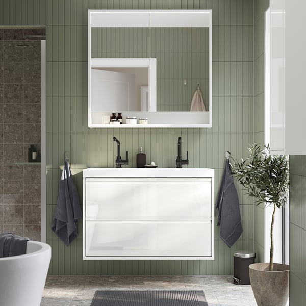 Modern white bathroom: ÄNGSJÖN cabinet, bathtub, mirror, plant.