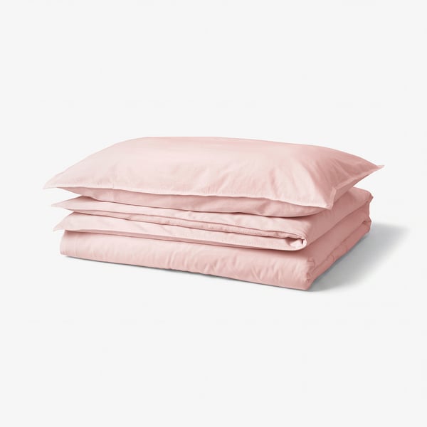 A neatly folded pink ÄNGSLILJA duvet cover and pillowcase set. Made of soft, 100% cotton.