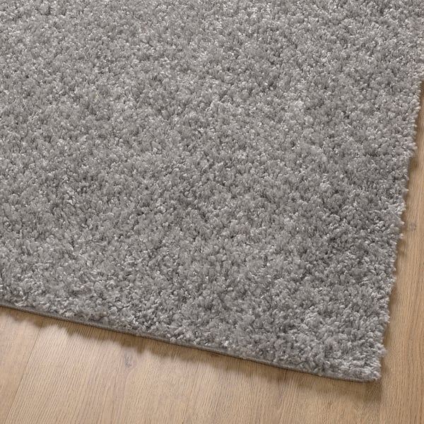 Soft, thick pile grey rug on wooden floor, showcasing plush texture and quality.